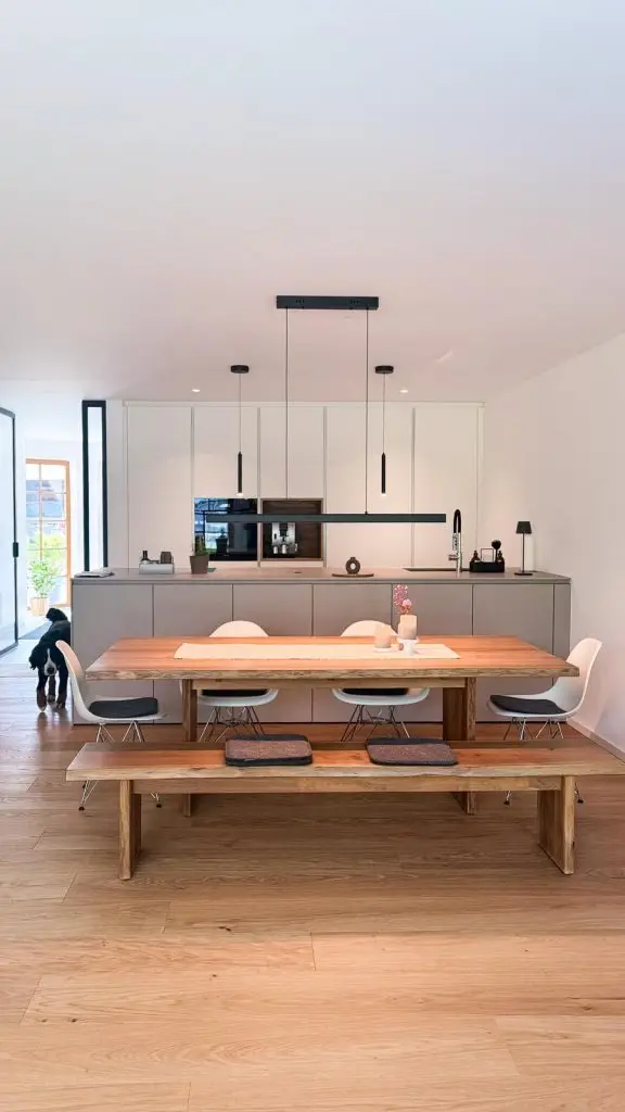 Moderne Küche nach Umbau mit neuer Kochinsel, Einbauschränken, Holzbank und Esstisch auf Eichenparkett