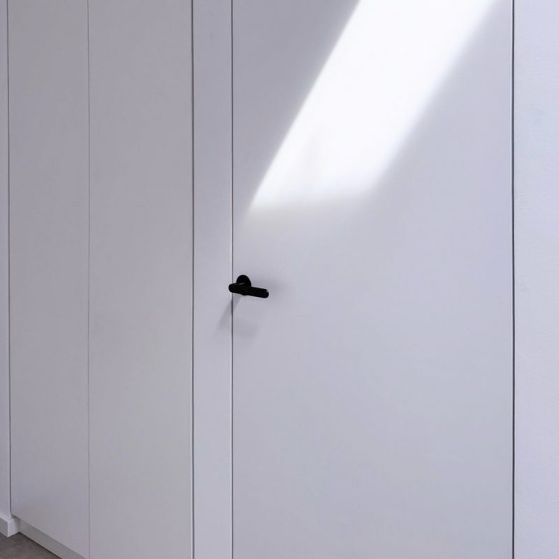 Detailansicht der bündigen Türen im Eingangsbereich des GERBERHAUS16 mit Lichteinfall und schwarzer Griffgarnitur