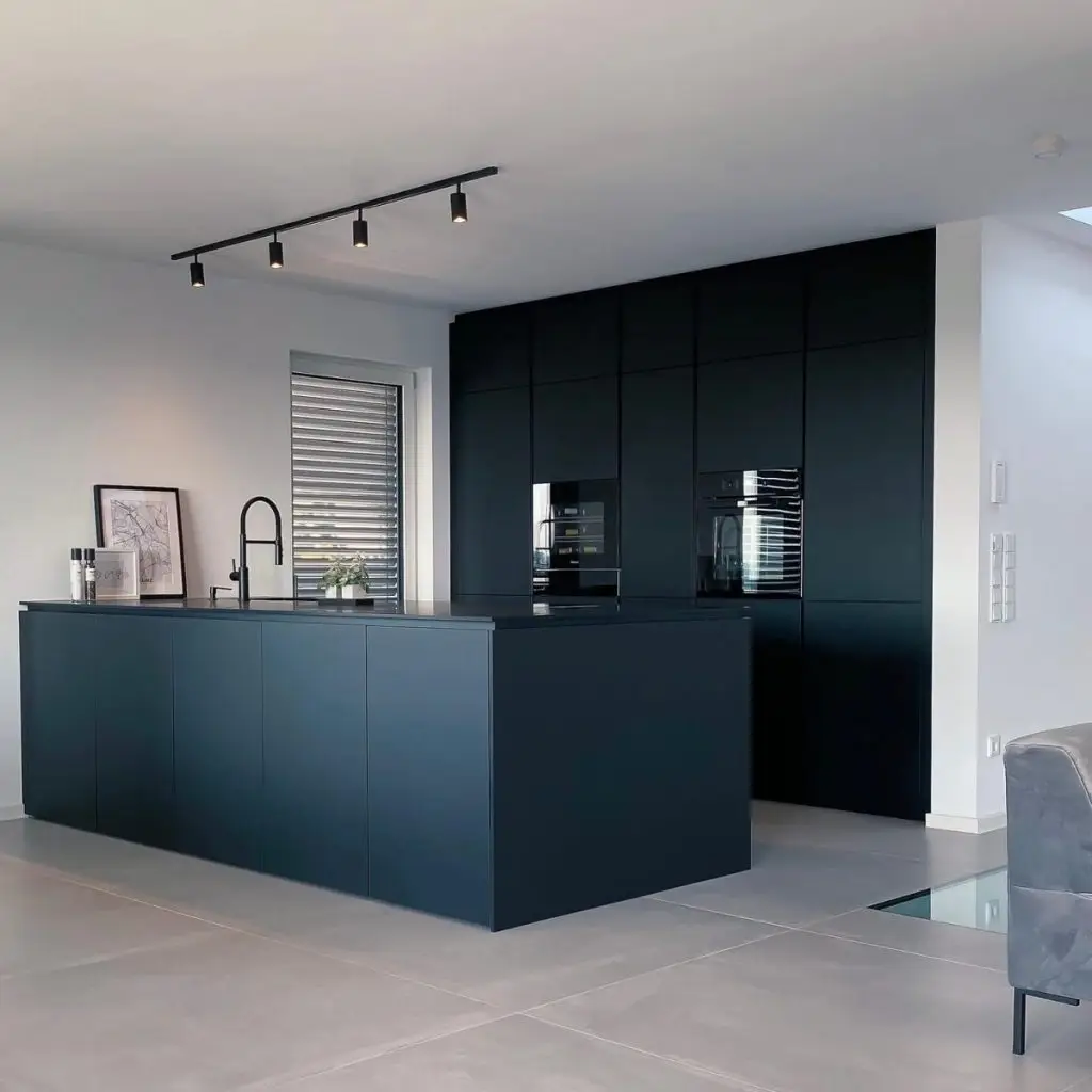 Moderne schwarze Küche mit Fenix Fronten und Arbeitsplatte, ausgestattet mit einer Kücheninsel.