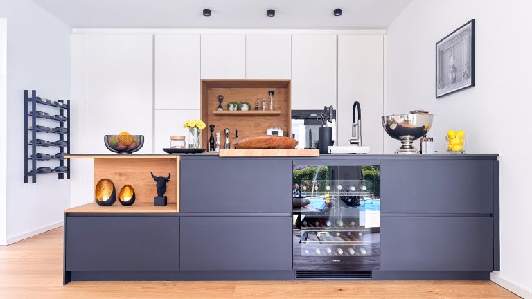 Küche im GERBERHAUS12 mit anthrazitfarbenen FENIX-Fronten, Holzregal und Weinkühlschrank