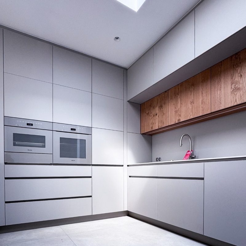 Moderne Einbauküche mit grifflosem Design, hellen Fronten und Holzakzenten, hochwertige Küchenschreinerei im Einfamilienhaus #GERBERHAUS16