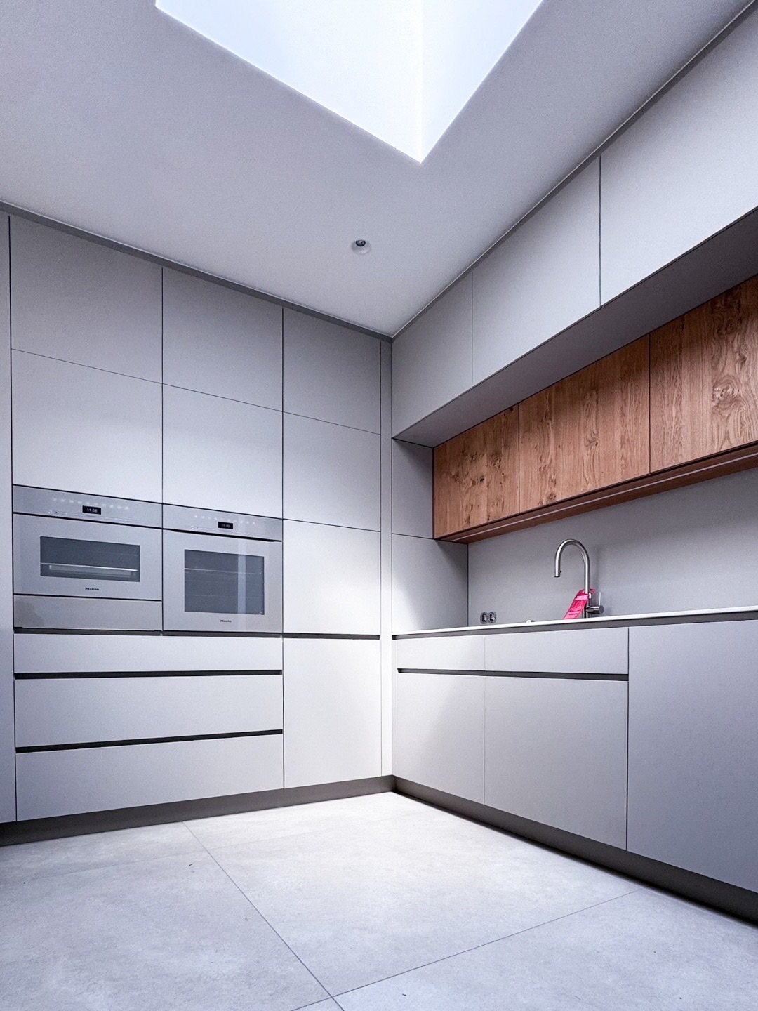 Grifflose graue Küche mit Holzakzent und Miele-Geräten in Pearl Beige im GERBERHAUS16
