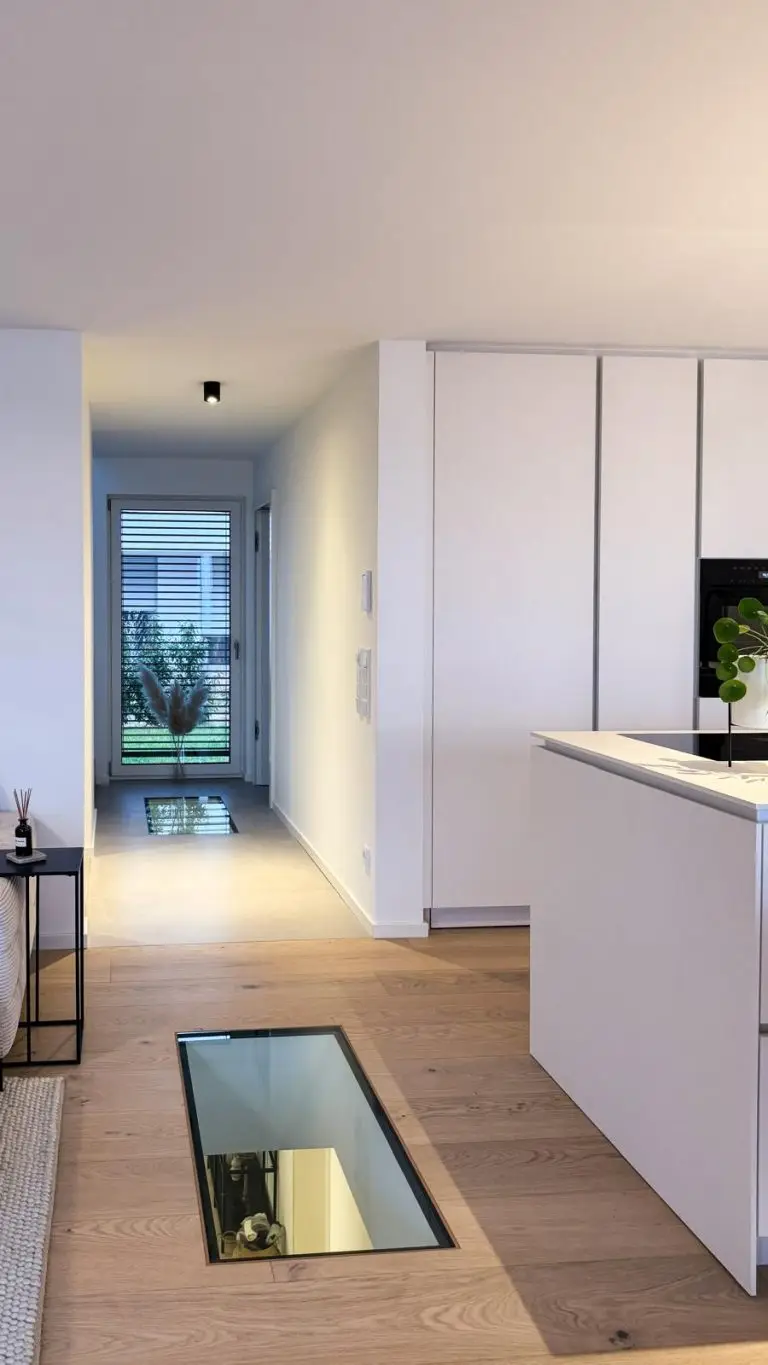 Offener Wohnraum mit moderner Küche, Glasboden und Eichenparkett im GERBERHAUS11B