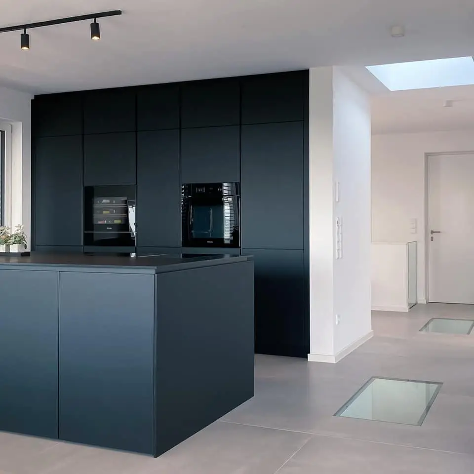 Moderne Küche im Gerberhaus5 mit schwarzen Fenix Arbeitsplatten, Miele Geräten und schwarzen Einbauschränken