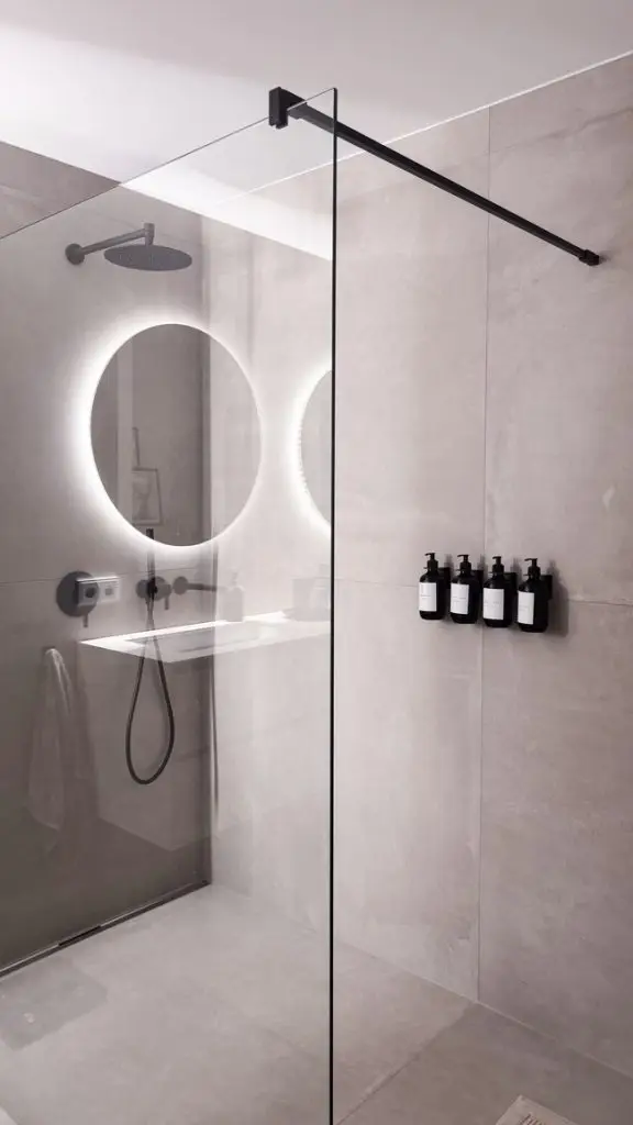 Dusche mit schwarzem Glasprofil und beleuchtetem Spiegel im GERBERHAUS11B