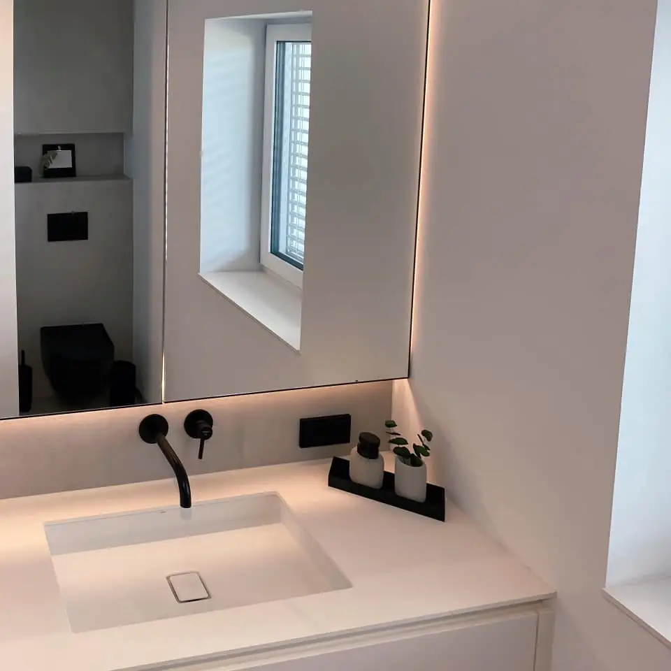 Modernes Badezimmer im Gerberhaus5 mit Doppelwaschtisch, Fenix Fronten, schwarzen Armaturen und großem Spiegelwandschrank