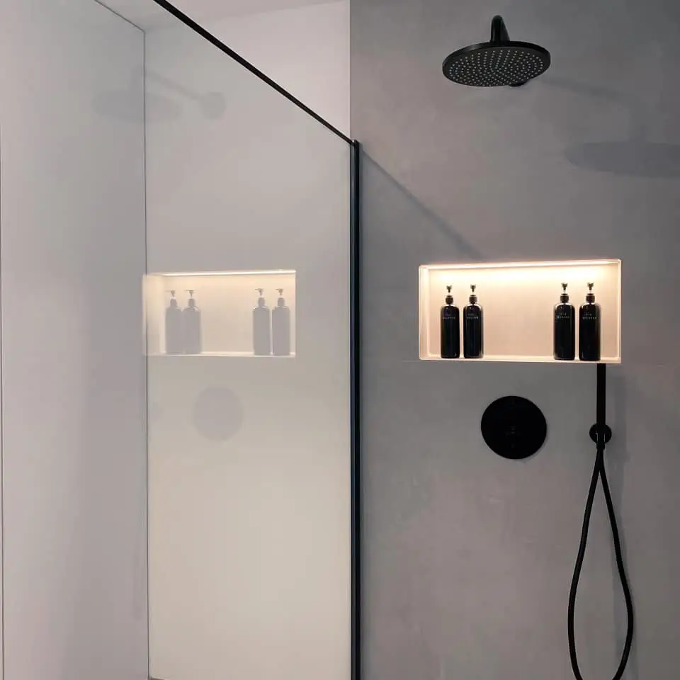 Moderne Dusche im Gerberhaus5 mit schwarzer Regendusche, integrierter Nische, schwarzen Armaturen und fugenlosem Microzement