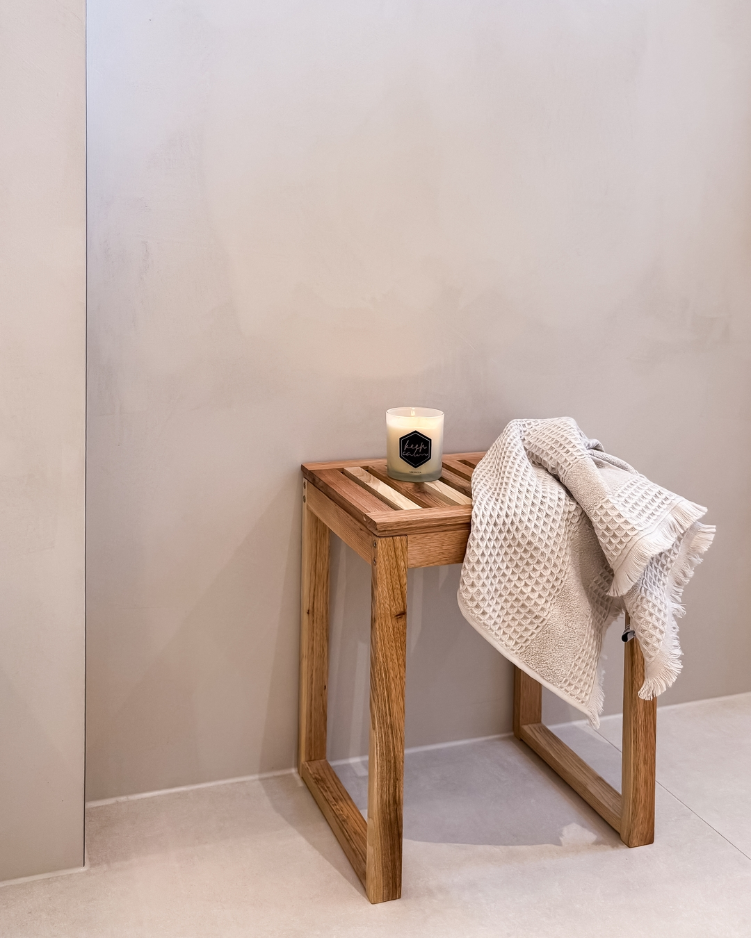 Helle Badwand mit Holzhocker und Handtuch im GERBERHAUS U04