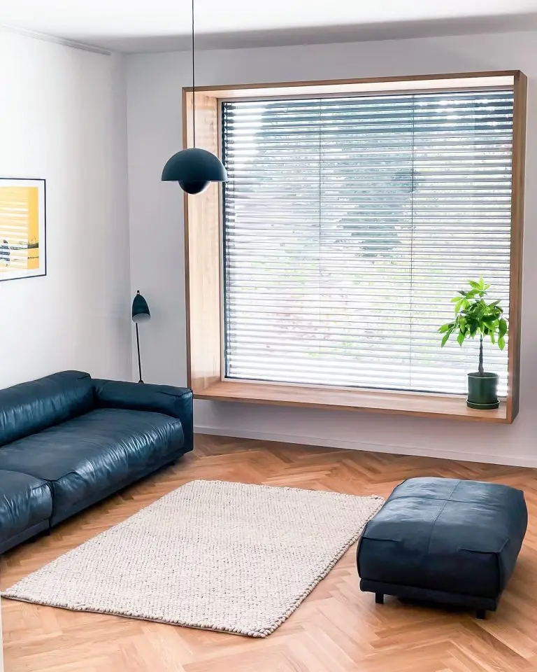 Wohnzimmer im Gerberhaus8 mit schwarzem Ledersofa, Holzsitznische und modernem Hängelicht