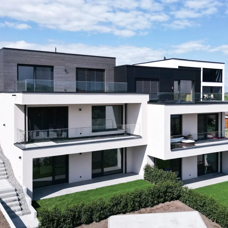 Außenansicht eines modernen, mehrstöckigen Hauses mit großen Glasflächen und Balkonen, GERBERHAUS11.