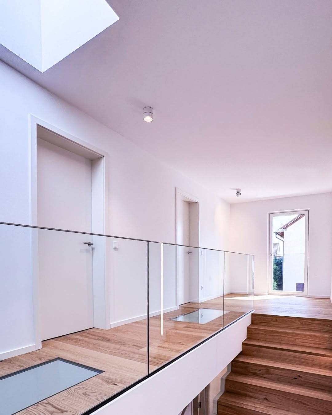 Galerie im Obergeschoss des GERBERHAUS15 mit rahmenlosem Glasgeländer, begehbaren Glasbodenelementen, Eichenboden und Oberlicht