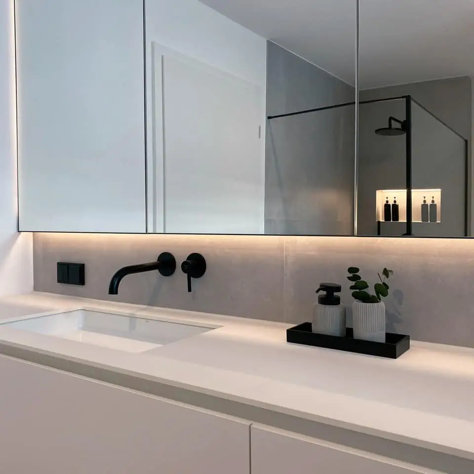 GERBERHAUS5: Waschtisch mit schwarzer Armatur und beleuchtetem Spiegelschrank