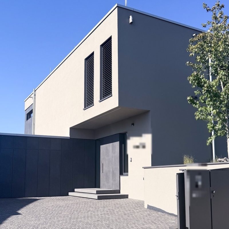 Eingangsbereich mit Haustür als Sonderanfertigung, verkleidet mit Trespa, fugenbündig auf Linie mit der Garage