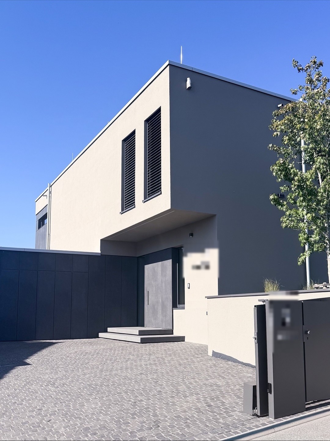 Eingangsbereich mit Trespa-verkleideter Haustür und auskragendem Obergeschoss
