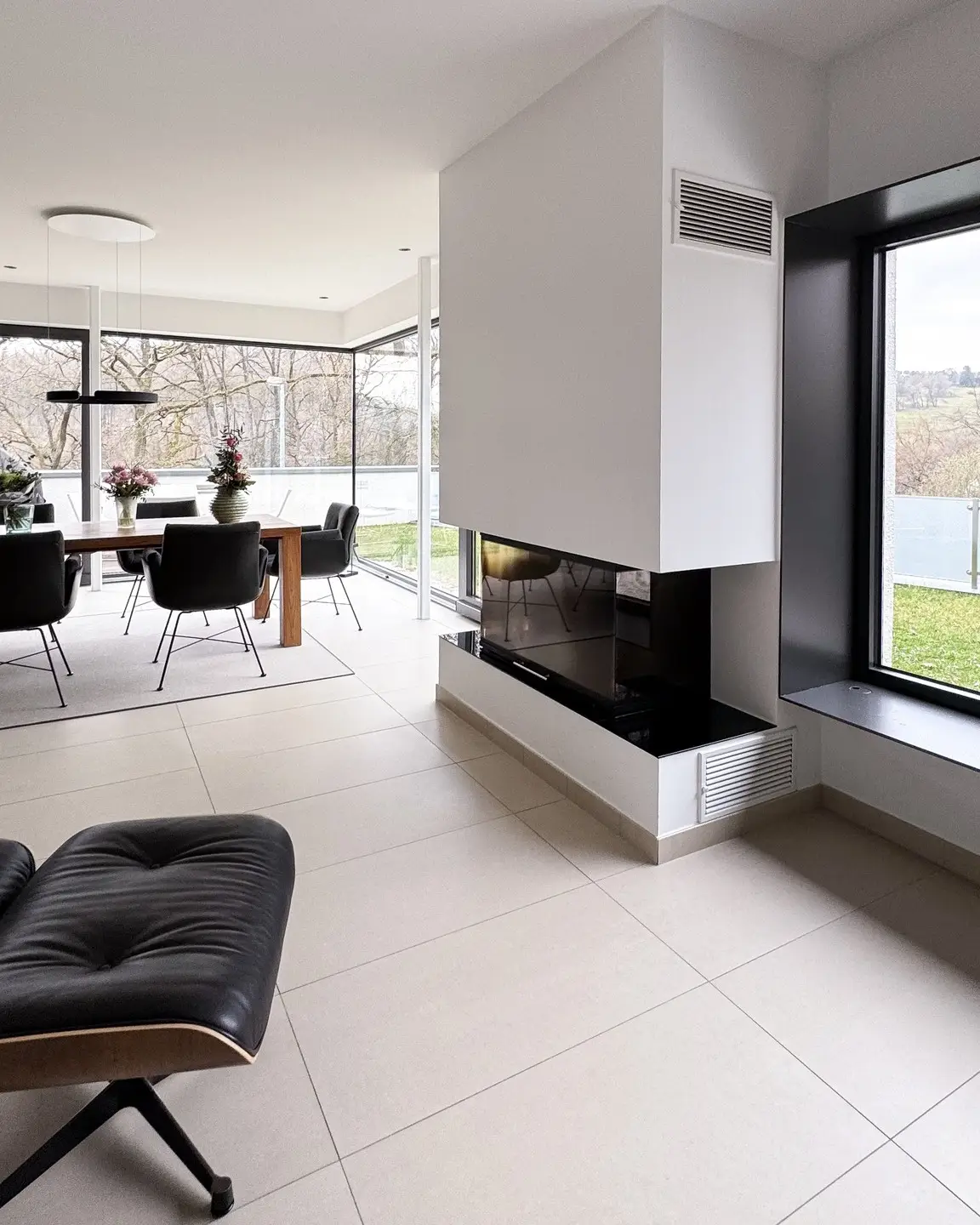 Wohnzimmer mit Kamin und großer Fensterfront beim Umbau im Rheingau