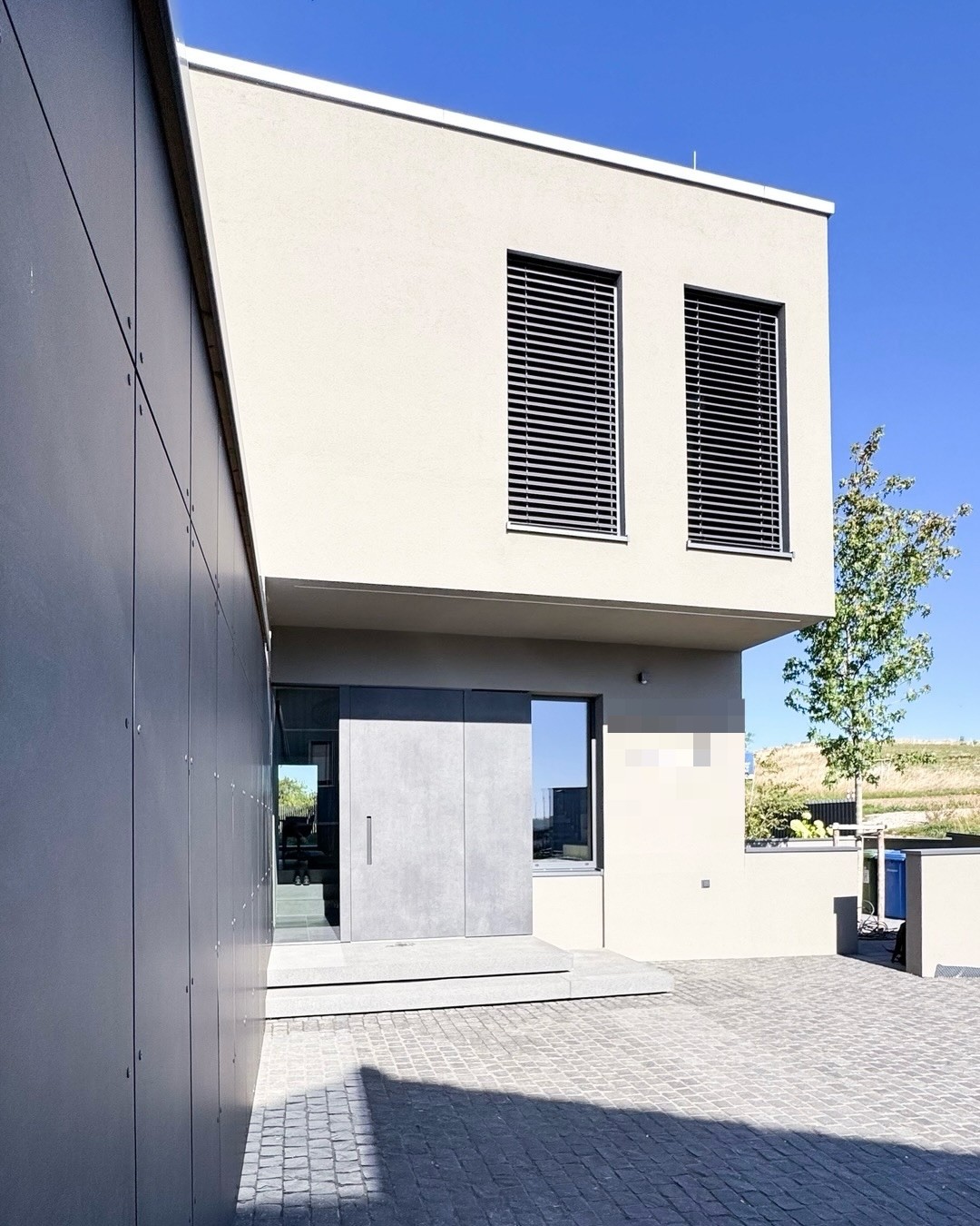 Maßgefertigte Haustür mit Trespa-Beplankung unter dem auskragenden Obergeschoss